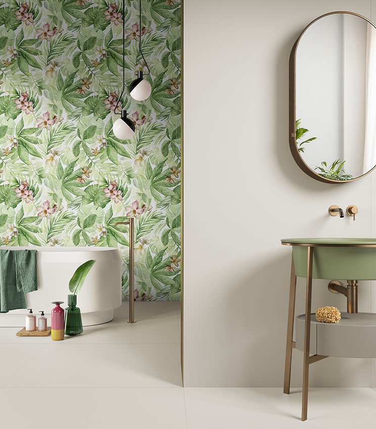 Modern bathroom featuring a tropical-patterned wall, white freestanding bathtub, and green sink with an oval mirror.
