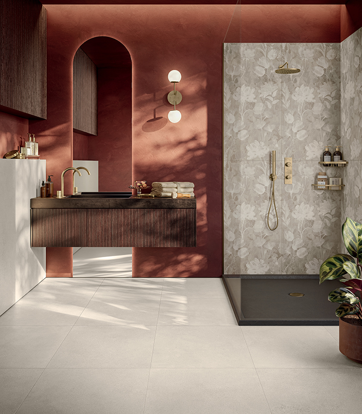 Contemporary bathroom with a warm, tactile character, featuring floor and wall surfaces from Panaria Ceramica’s Formula collection. Form Cotton Naturale creates a neutral base, while the floral Garden Naturale decoration defines the shower area, contrasting elegantly with the terracotta walls and dark furnishings.