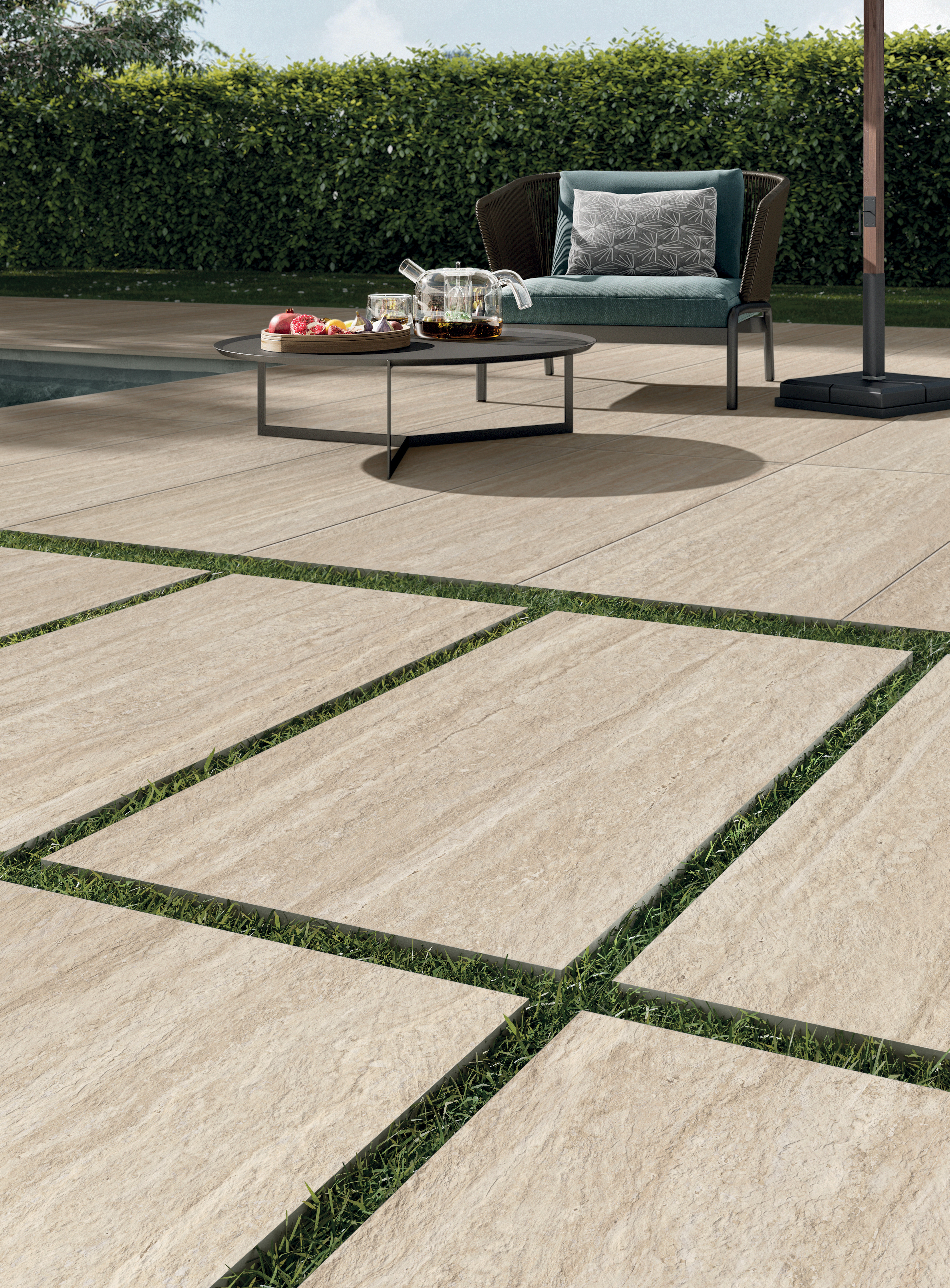 Near ground-level view of a 20 mm outdoor porcelain stoneware floor in a travertine effect in front of a swimming pool | Perpetual Travertino collection by Panaria Ceramica